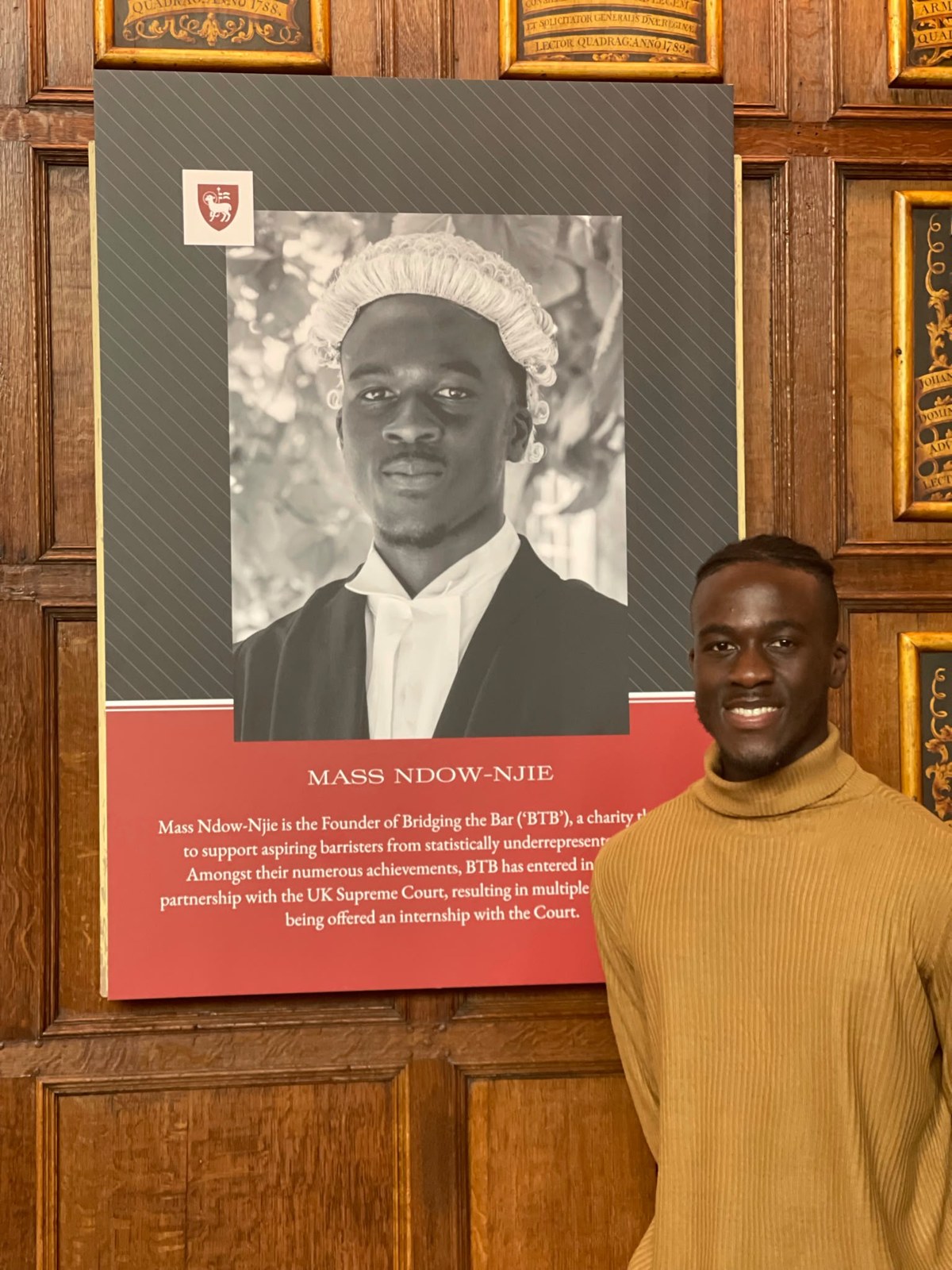 Mass Ndow-Njie beside his founder portrait on the Bridging the Bar honour board at an Inn of Court